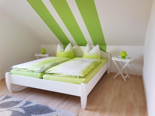 Harzer Auszeit في Hattorf: غرفة نوم بسرير بخطوط خضراء وبيضاء