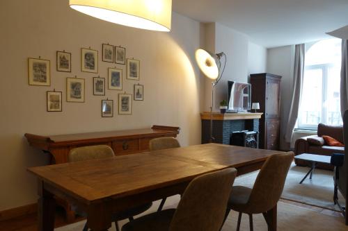 a dining room with a wooden table and chairs at Temps de Pose in Ypres