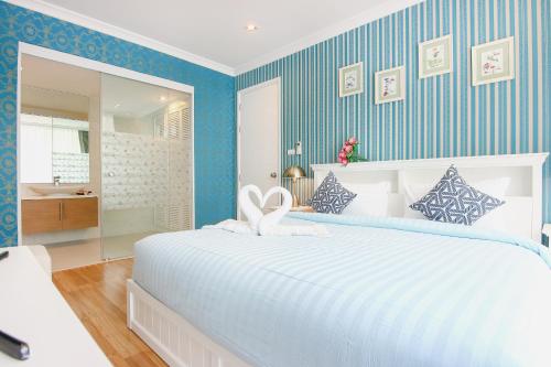 a bedroom with a large white bed and a bathroom at My Resort Hua Hin B111 in Hua Hin