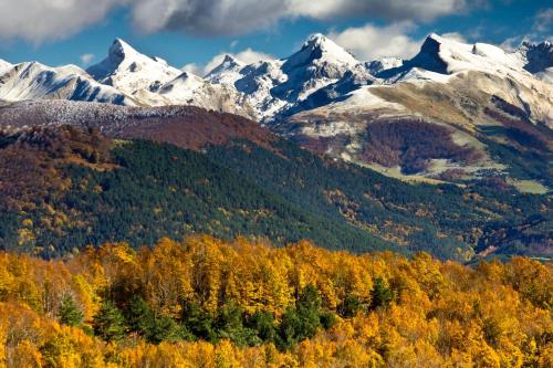 a mountain range with autumn trees and snow at Argonz Etxea in Urzainqui