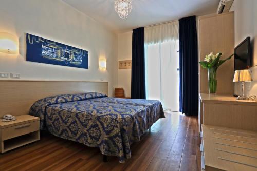Habitación de hotel con cama y ventana en Hotel Castiglione, en Lignano Sabbiadoro