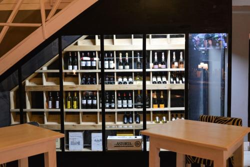a room with two tables and a shelf of wine bottles at Pili Pili Boutique Hotel in Kigali