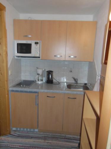 a small kitchen with a sink and a microwave at Haus Schönleiten in Wagrain