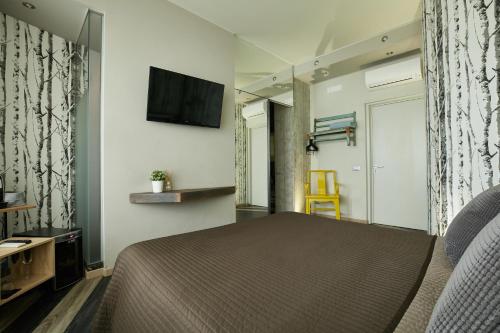 a bedroom with a bed and a tv on a wall at 15 Quindici by Serendipity Rooms in Milan