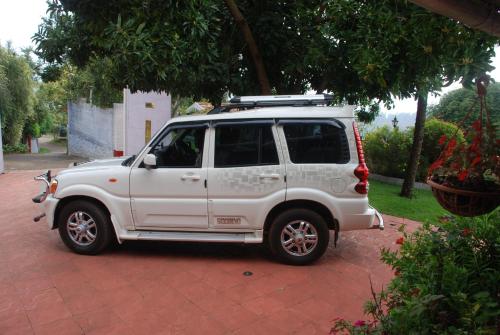 a white suv parked on a brick driveway at Colonial 4 B/R Home, Great for Families, Coonoor in Coonoor