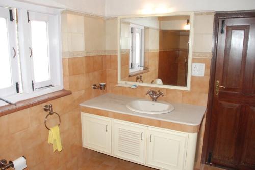 a bathroom with a sink and a mirror at Colonial 4 B/R Home, Great for Families, Coonoor in Coonoor