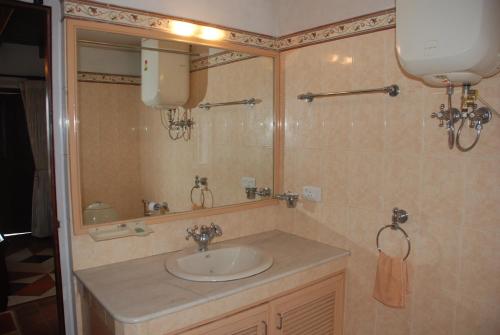 a bathroom with a sink and a mirror at Colonial 4 B/R Home, Great for Families, Coonoor in Coonoor