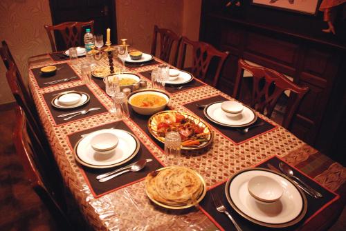 a table with plates and bowls of food on it at Colonial 4 B/R Home, Great for Families, Coonoor in Coonoor