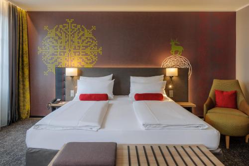 a hotel room with two beds and a chair at Mercure München City Center in Munich
