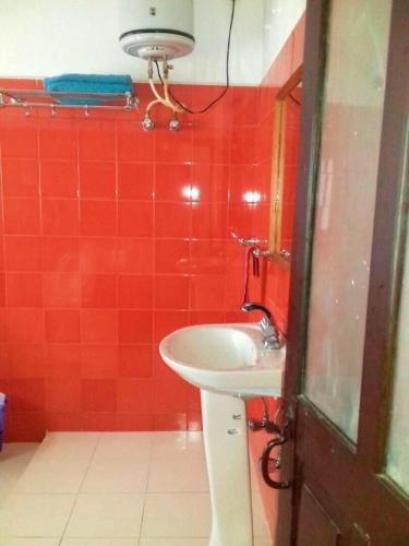 a bathroom with a sink and a red tiled wall at Colonial 4 B/R Home, Great for Families, Coonoor in Coonoor