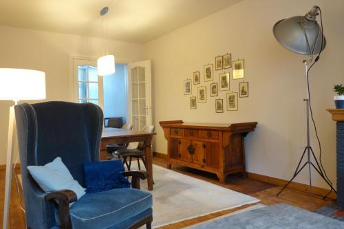 伊普爾的住宿－Temps de Pose，客厅配有蓝色椅子和书桌