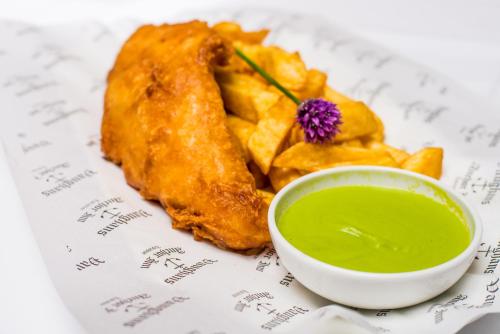 a plate of food with a bowl of green dipping sauce at Vaughans Anchor Inn in Liscannor
