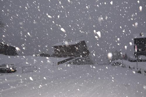 a snow storm in a city with buildings at Celine 9, Champery in Champéry