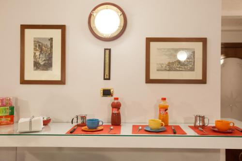 a counter with two plates and a clock on the wall at Hotel Ausonia in Naples