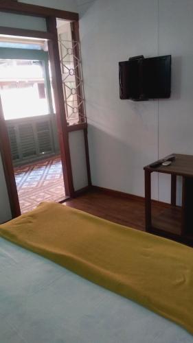 a room with a bed and a television on a wall at Carlton Hotel Mumbai - Behind Taj Mahal Palace Colaba Mumbai in Mumbai