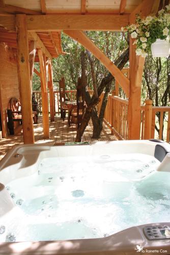 a hot tub sitting under a wooden pavilion at Cabane d'Amour in Béziers