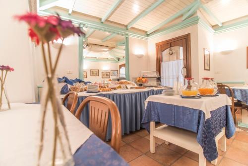 a dining room with tables with blue and white tablecloths at Hotel Terranova in Olbia