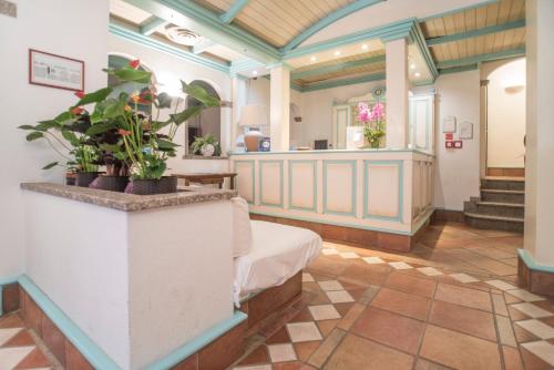 una camera ospedaliera con un letto e piante in vaso di Hotel Terranova a Olbia