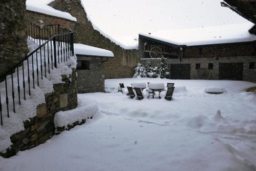 a yard covered in snow with two benches at Cal Marrufès in Puigcerdà