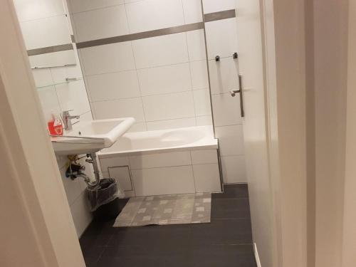 Baño blanco con lavabo y espejo en Wohnung Weitblick Haan en Haan