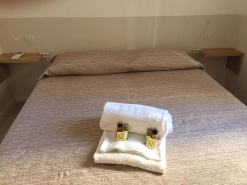 - un lit avec 2 serviettes et 2 bouteilles dans l'établissement Napoleon, à Cannes