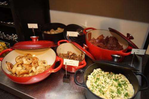 a counter with three pots and pans of food at The Delphi - Amsterdam Townhouse in Amsterdam
