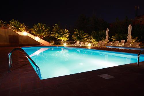 a large swimming pool at night with lights at Grand Hotel Admiral Palace in Chianciano Terme