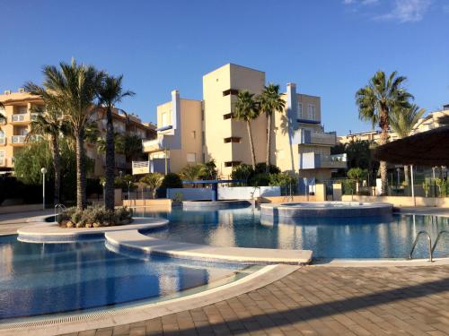 a large swimming pool with palm trees and buildings at CALAS AGUAMARINA - Campoamor - Primera Linea in Campoamor