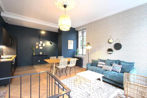 a living room with a blue couch and a table at La chouette d'or in Dijon