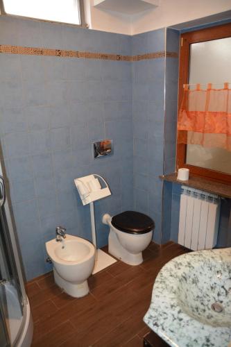 a blue bathroom with a toilet and a sink at Tata Carota in Chianocco