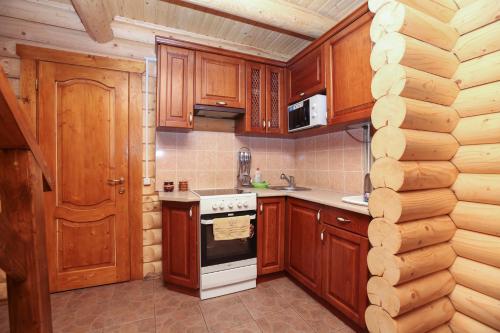 a kitchen with wooden cabinets and a stove top oven at Cottage Goyra in Yaremche