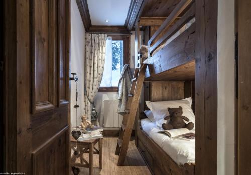 una camera con letto a castello e un orsacchiotto. di Appartement 35m² Domaine du Jardin Alpin a Courchevel