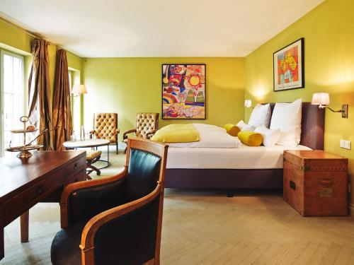 a bedroom with a large bed and a desk and chair at Auberge de Temple in Johannesberg