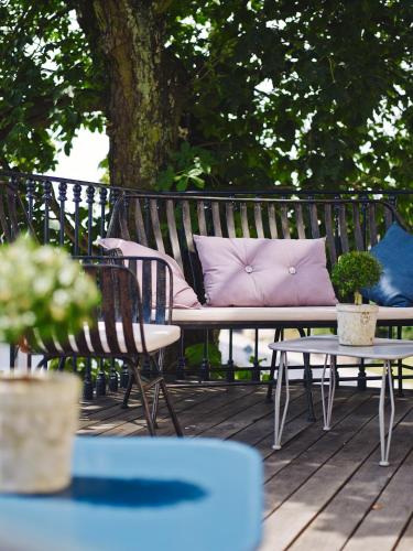 a bench with a pink pillow sitting on a deck at Auberge de Temple in Johannesberg
