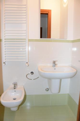 a white bathroom with a sink and a mirror at Rinaldi House in Torriana