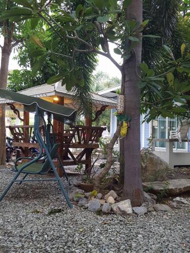 a tree with a bench next to a tree at Charlie's Bungalows in Ko Si Chang