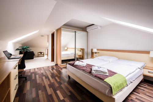a bedroom with a large bed and a mirror at Hotel Garzon Plaza in Győr