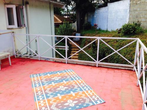 a patio with a fence and a mat on the ground at Colonial 4 B/R Home, Great for Families, Coonoor in Coonoor