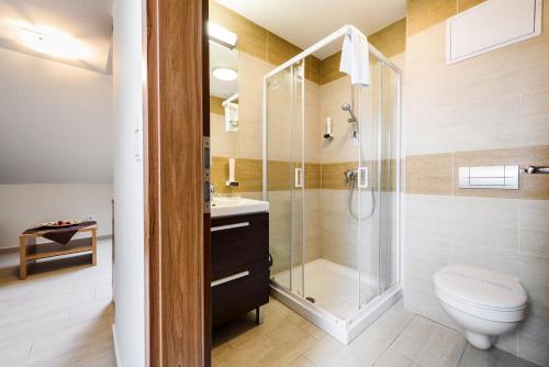 a bathroom with a shower and a toilet and a sink at Hotel Garzon Plaza in Győr