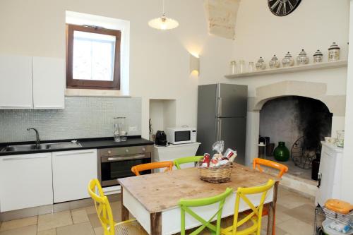 a kitchen with a table with yellow chairs and a kitchen with a stove at Villa Pardonise- Puglia-Salento-Casa vacanze in Diso