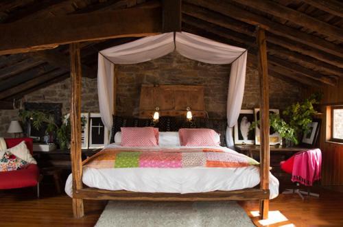 um quarto com uma cama de dossel em madeira com almofadas cor-de-rosa em Casa Tejada em Rúerrero