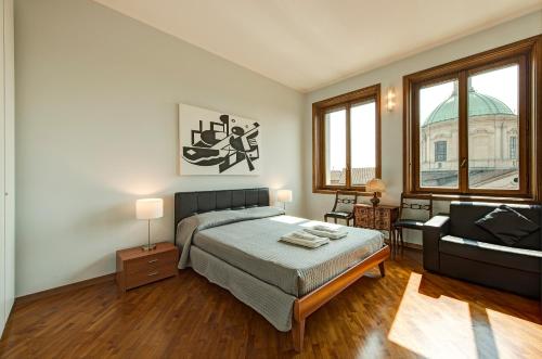 ein Schlafzimmer mit einem Bett und einem Sofa in der Unterkunft BnButler - Duomo Apartment - Galleria Unione in Mailand