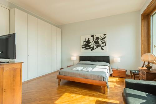 ミラノにあるBnButler - Duomo Apartment - Galleria Unioneのベッドルーム(ベッド1台、テレビ、ソファ付)