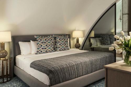 1 dormitorio con 1 cama grande y espejo en Marquis SkySuites, en Ciudad de México