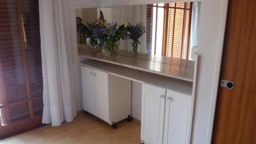 a room with a counter with a vase of flowers on it at Las Frambuesas in Viedma
