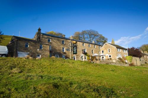 a large building on top of a grassy hill at The Punch Bowl Inn in Feetham