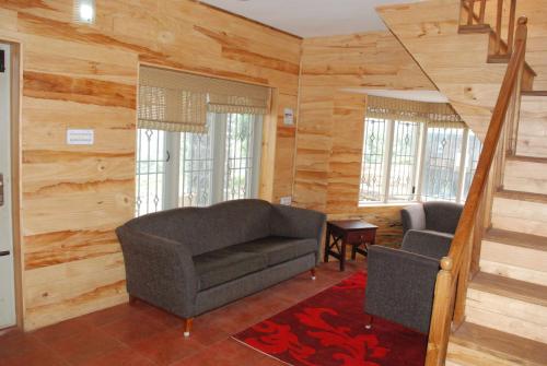 a living room with a couch and a chair at Relaxing 2 B/R Estate House, Deenaty, Tamil Nadu in Coimbatore