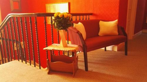 a living room with a couch and a vase of flowers at Victoria Hotel in Blairgowrie