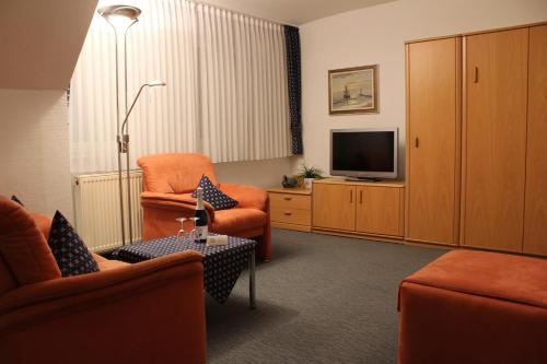 a living room with two chairs and a television at Haus Kleemann in Norderney