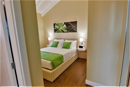 a bedroom with a bed with green pillows at Quinta do Basalto in Piedade